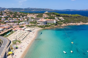 Eine Küstenstadt mit Strand, klarem, blauem Wasser und Gebäuden mit Balkonen mit Blick auf das Meer.