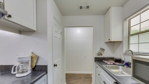 A modern kitchen with a coffee maker, sink, and dishwasher. - Pet-Friendly FSU Rental w/ Private Fenced Yard (Tallahassee)