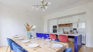 Una cucina moderna con mobili bianchi, forno integrato e frigorifero in acciaio inossidabile.