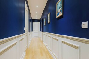 A hallway with blue walls, white trim, and wooden flooring. - Luxurious apartment - 4BR/10P- Ternes/Pereire (Paris)