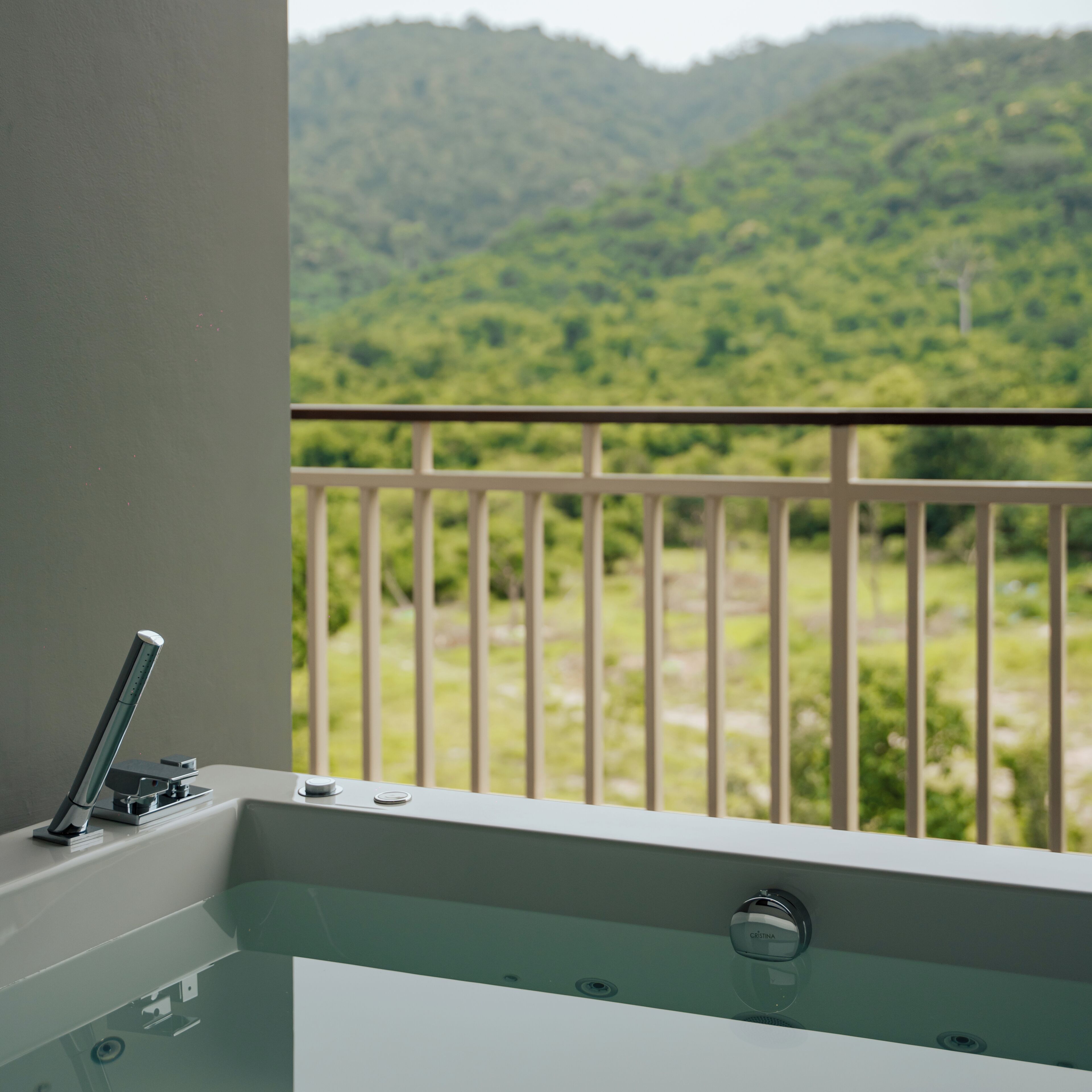 A bathroom with a bathtub, a faucet, and a control knob.