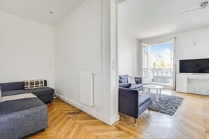 Ein modernes Wohnzimmer mit einer Couch, einem Couchtisch und einem Fernseher.