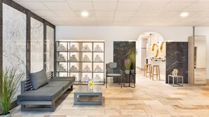 A modern living area with a sofa, coffee table, and a wall with framed artwork.