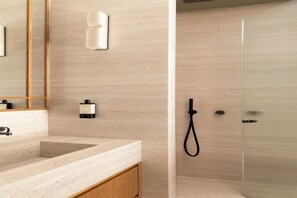 A bathroom with a large mirror, a sink, a towel dispenser, and a glass shower enclosure. - Luxury Apt climatisé - 6P/3BDR - Arc de Triomphe (Paris)