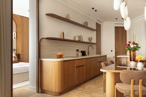 Eine moderne Küche mit Holzschränken, einer zentralen Kochinsel und einem Essbereich mit Tisch und Stühlen.
