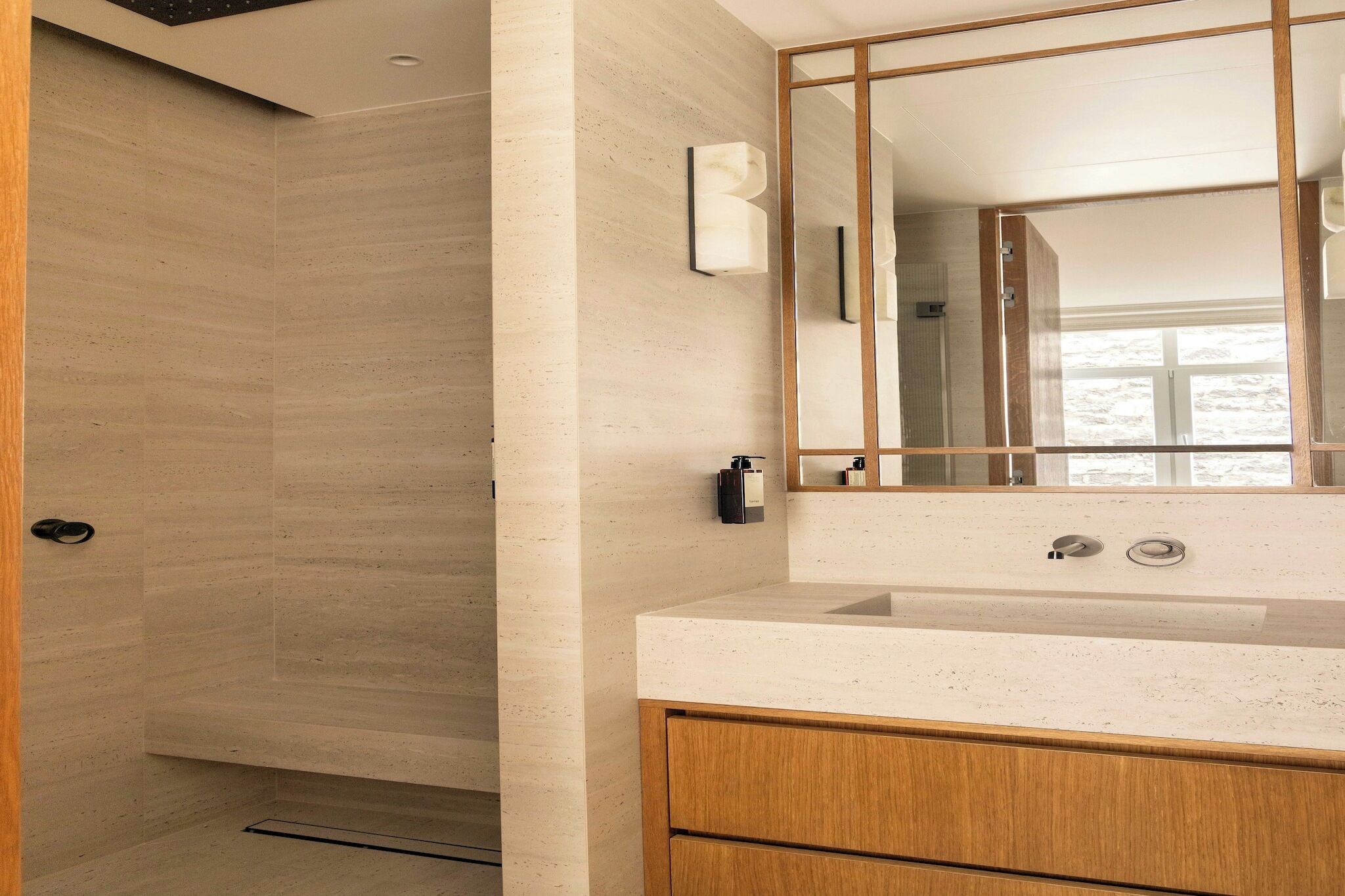 Une salle de bain moderne avec un meuble-lavabo en bois, un grand miroir et un espace douche.