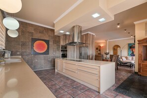 A modern kitchen with a central island, built-in oven, and stainless steel appliances. - Luxury Villa Leona Moraira (Moraira)