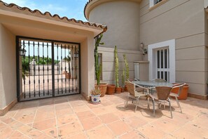 A patio with a table and chairs, potted plants, and a gate. - Luxury Villa Leona Moraira (Moraira)