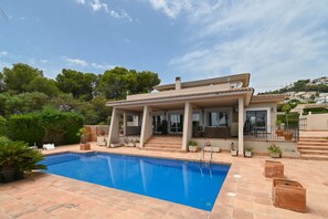 A two-story house with a swimming pool, outdoor furniture, and a view of a hilly landscape. - Luxury Villa Leona Moraira (Moraira)