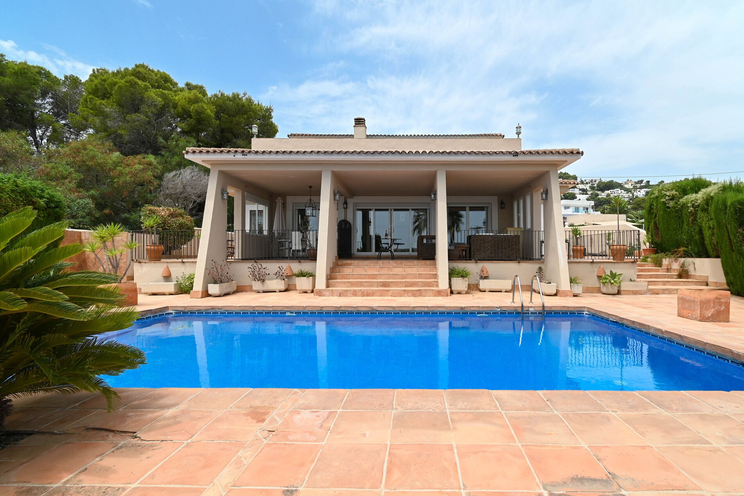 Une maison à deux étages avec une piscine à l’avant.