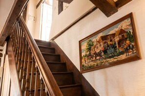 Eine Holztreppe mit einem Wandbild einer ländlichen Szene.