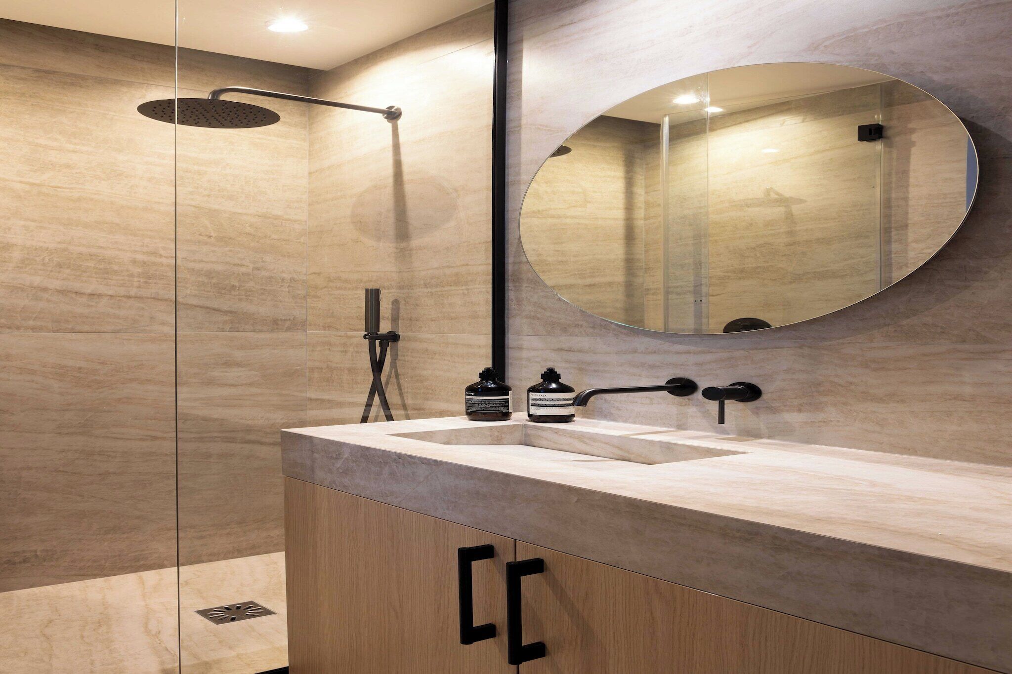 Ein modernes Badezimmer mit Dusche, Waschbecken und einem großen Spiegel.