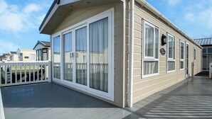 Een gebouw met grote ramen, een balkon en uitzicht op andere gebouwen.