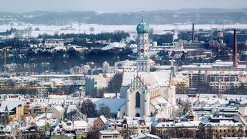 A cityscape with a prominent church with a green dome, surrounded by residential buildings and industrial structures.