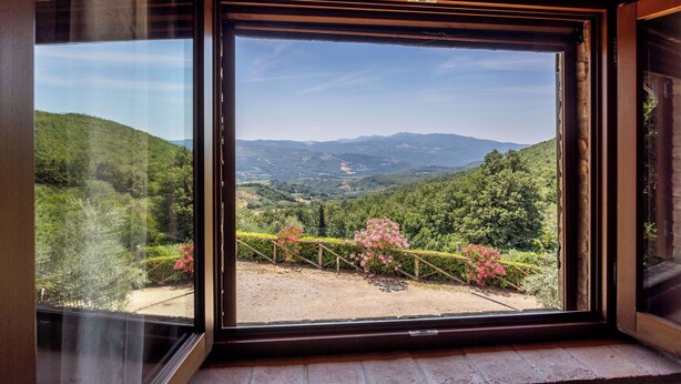 A room with a large window offering a view of a mountainous landscape. - Villa Daluma, Private Pool in Todi (Todi)
