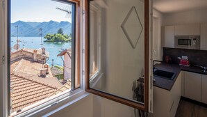 Cuina amb vista a un llac i muntanyes, microones i torradora.