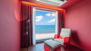 A room with a large window, a chair, and a floor lamp. - APEX HOTEL (Yangyang)