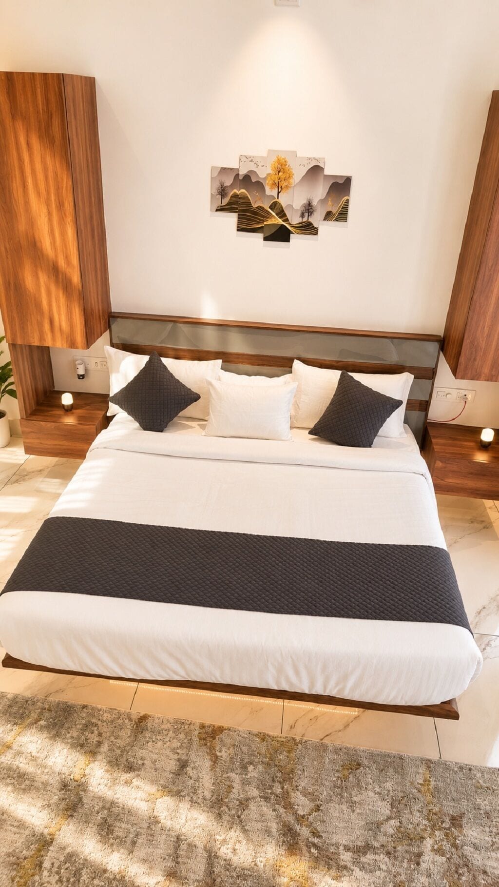 Une chambre moderne avec un grand lit, une tête de lit, des tables de chevet et une œuvre d’art accrochée au mur.