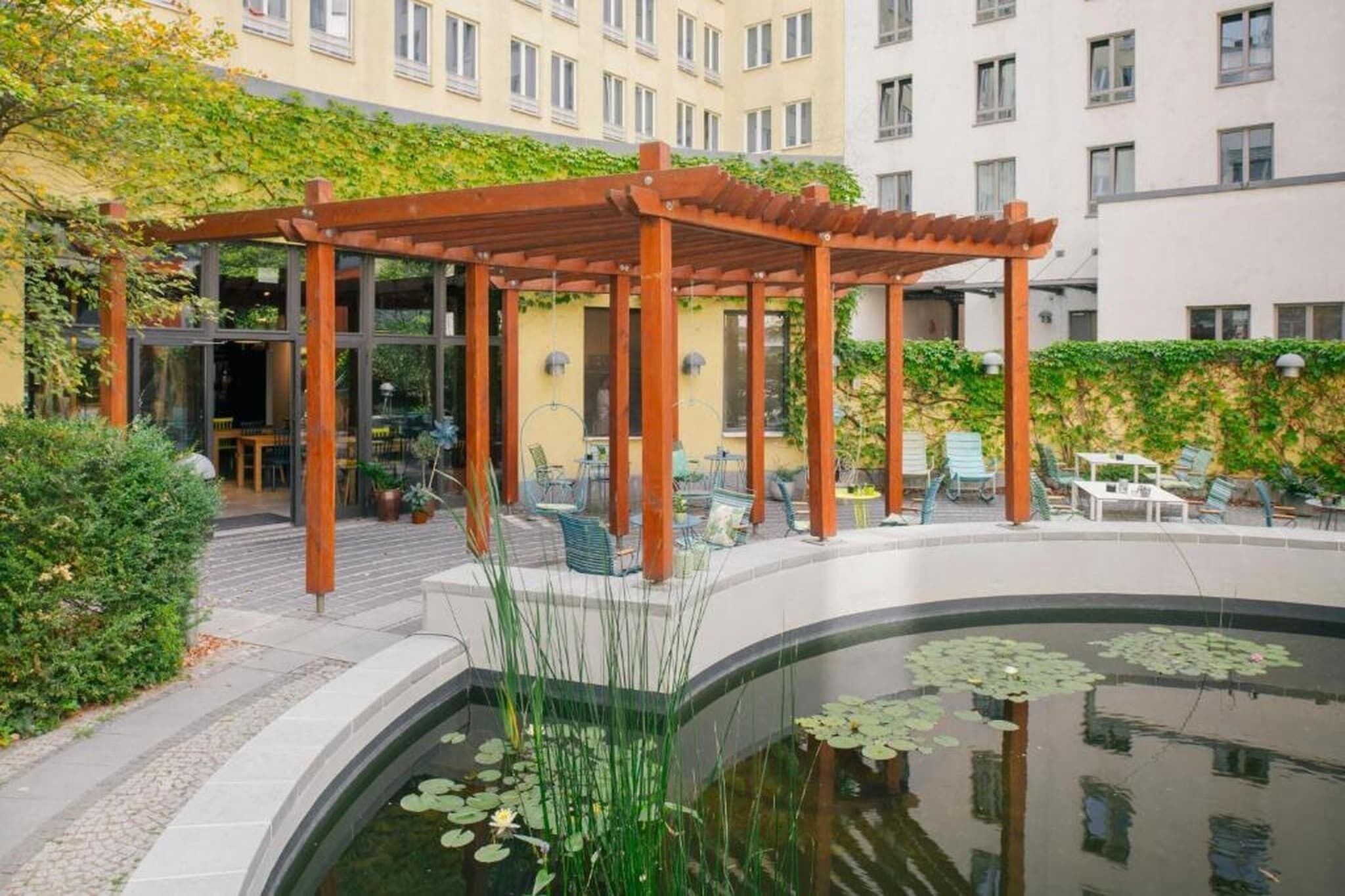 Un espace extérieur aménagé, abrité et doté d’une piscine et de verdure.