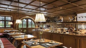 A rustic dining area with wooden tables, benches, and a central island with kitchenware.