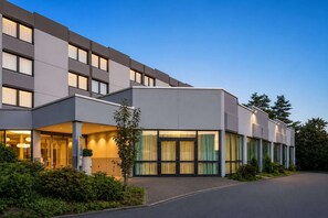 Ein modernes Hotel mit flacher Fassade, großen Fenstern und einem gut beleuchteten Eingang.