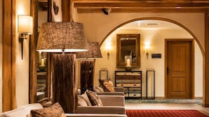 A lobby with a red carpet, a wooden reception desk, a wall-mounted mirror, and a sign that reads 'Willkommen im Haus'. - Sunday Hotel Garmisch Partenkirchen Standard Twin Room (Garmisch-Partenkirchen)