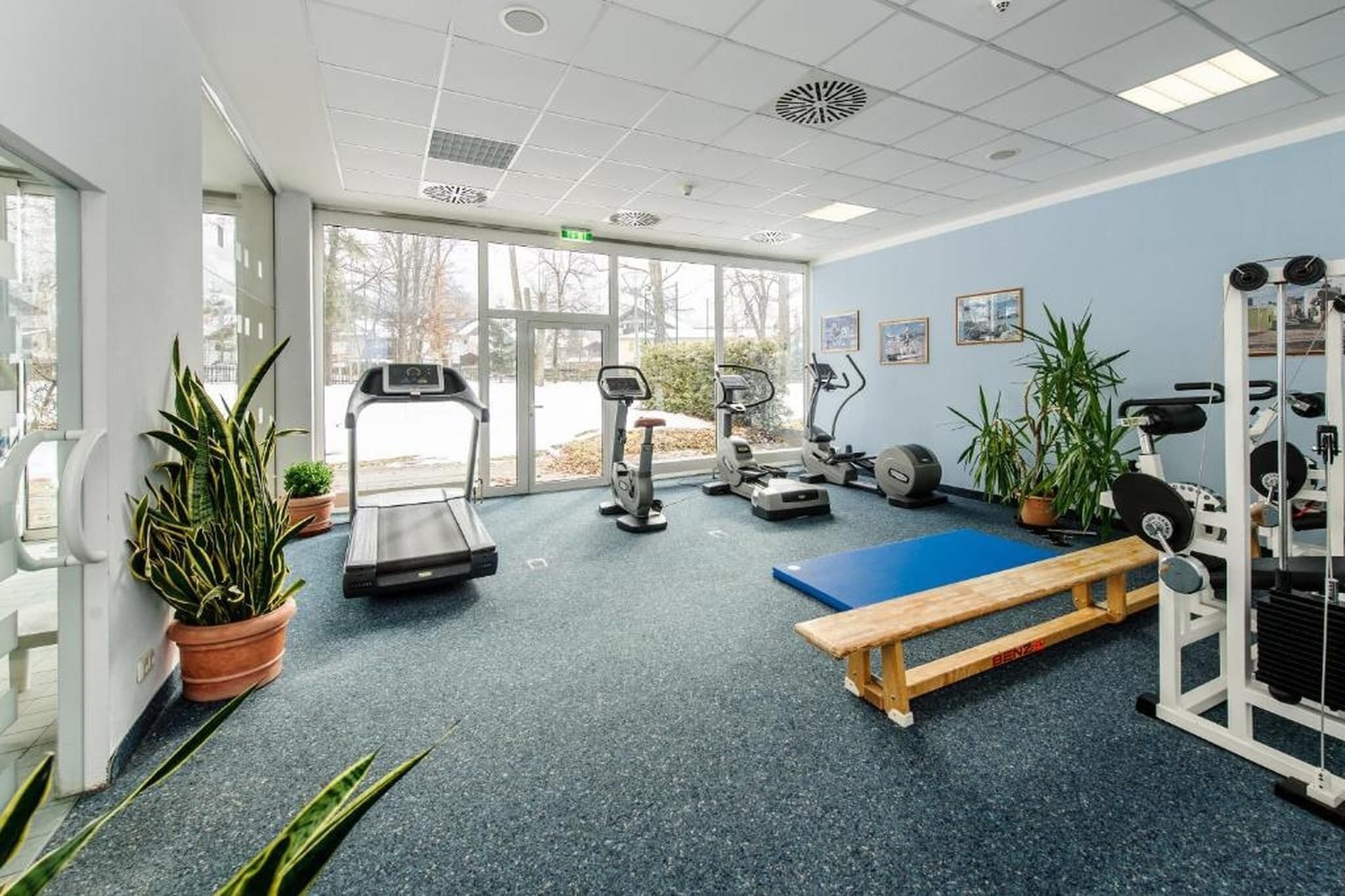 A gym with treadmills, stationary bikes, a rowing machine, and weightlifting equipment.