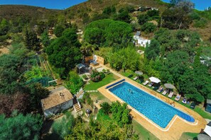 Propiedad residencial con piscina, jardín y vistas de las colinas circundantes.