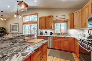 A kitchen with wooden cabinets, granite countertops, a stainless steel dishwasher, and a large stove. - 10 Mins Lake/Heavenly Ski, BBQ, Deck, Modern 3BD! (South Lake Tahoe)