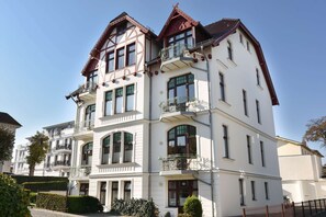 En bygning med flere etager, altaner og store vinduer, sandsynligvis et hotel eller et boligkompleks.