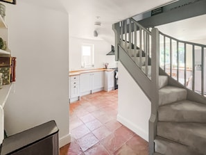 A staircase leading to a kitchen with white cabinets and a window. - 4 bedroom accommodation in Chelsworth (Chelsworth)