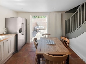 A kitchen with a wooden table, chairs, a refrigerator, and a view to an outdoor patio. - 4 bedroom accommodation in Chelsworth (Chelsworth)