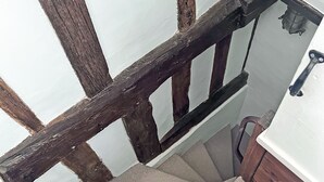 Una escalera con barandilla de madera y un rellano alfombrado.