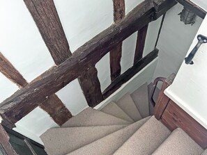 Eine Treppe mit hölzernem Geländer und einem Teppich belagten Podest.