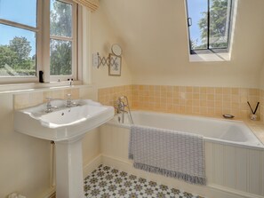 A bathroom with a sink, bathtub, and two windows. - 2 bedroom accommodation in Pulborough (Pulborough)