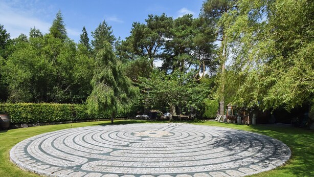A circular stone pattern on a lawn with surrounding trees. - 2 bedroom accommodation in Ennderdale (Ennderdale)