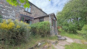 A stone building with a garden, a stone pathway, and a view of the sky. - Hendre Aled Farmhouse (Llanssannan)