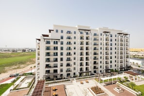 A multi-story hotel with balconies, a rooftop terrace, and a landscaped courtyard. - Bloomfields 2BR Fairways 2 Yas Golf  (Abu Dhabi)