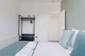 A room with a bunk bed, a door, and a bed with pillows. - Newly Renovated 4BDR Home Near Notting Hill (Greater London)
