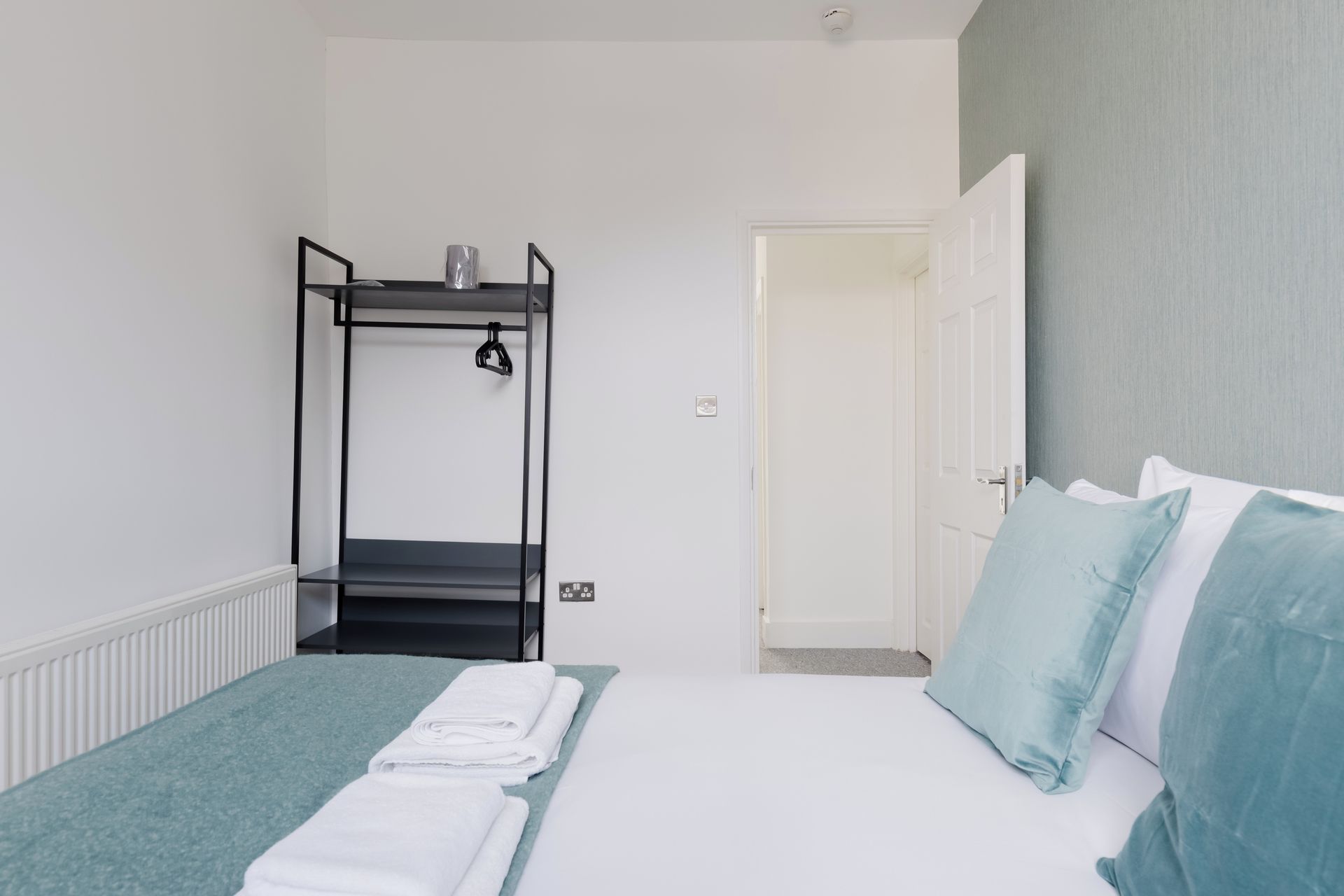 Une chambre avec un lit superposé, une porte et un lit avec des oreillers.