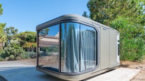 A modern, compact RV with a large window, parked on a concrete surface. - Guest Room “Futura 1 - House of the Future” in Borgo, 50 m from the Beach (Borgo)