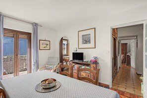 Une chambre avec un lit, une télévision, une bibliothèque et une fenêtre donnant sur un beau paysage.
