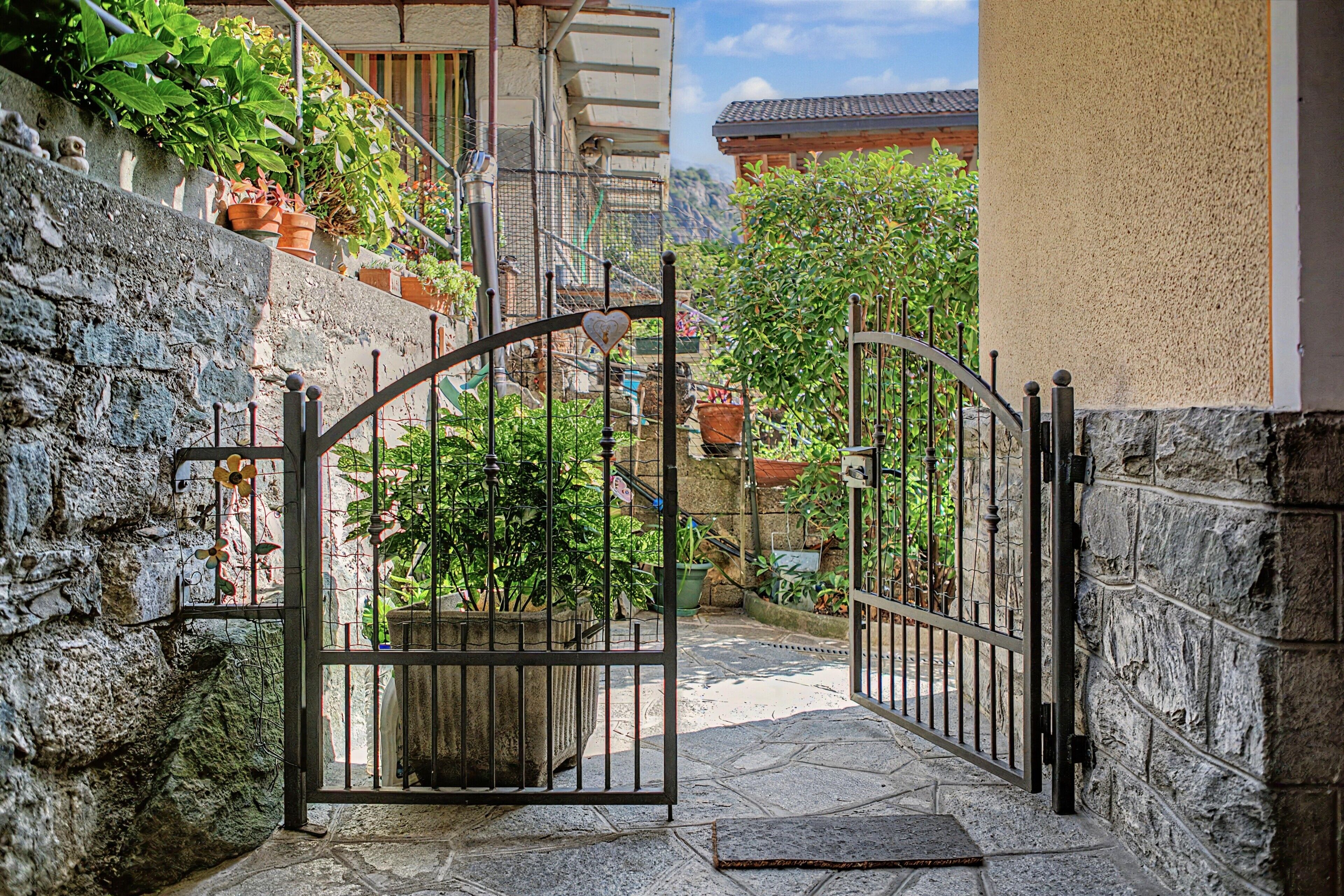 Una entrada porticada con un camino de piedra que conduce a un edificio con techo de tejas.