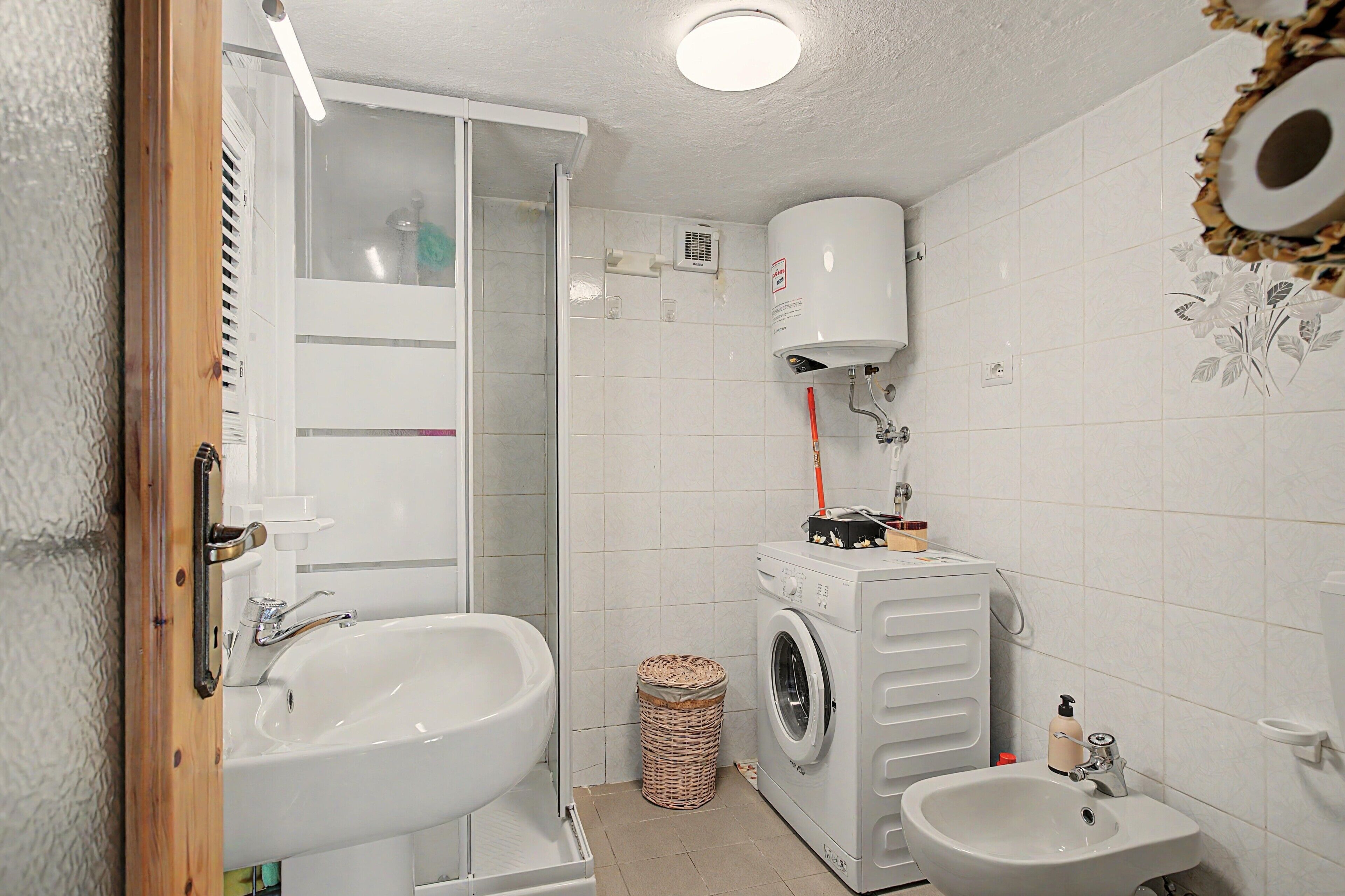 Ein Badezimmer mit Waschbecken, Waschmaschine und Toilette.