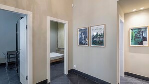 A hallway with a bed, a chair, and three framed posters on the wall. - The Gallery House by Wonderful Italy (Genova)
