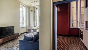 A living room with a sofa, TV, and patterned carpet. - The Gallery House by Wonderful Italy (Genova)