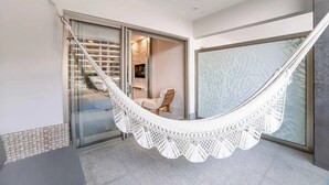 Eine Hängematte in einem modernen Zimmer mit einer Schiebetür zu einem Balkon.