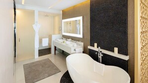 Ein modernes Badezimmer mit einer freistehenden Badewanne, einem großen Spiegel und einem Waschtisch mit Waschbecken und Handtuchhalter.