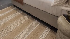 Ein modernes Schlafzimmer mit einem Bett, einem Fernseher, einem Fenster mit Vorhängen und einer Klimaanlage.
