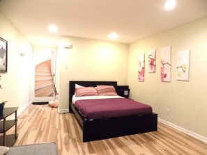 Ein Schlafzimmer mit einem Bett, einer Treppe und einer Tür zu einem weiteren Raum.